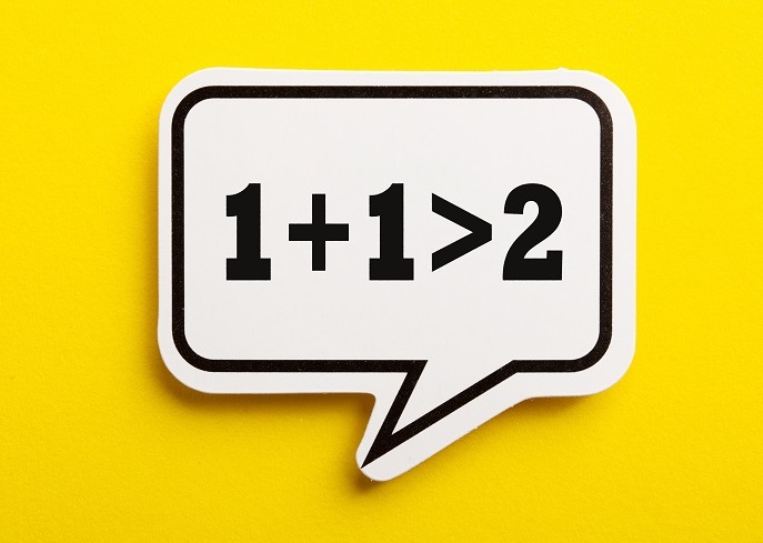 Speech bubble with equation "1 + 1 > 2" showing concept of "synergy"